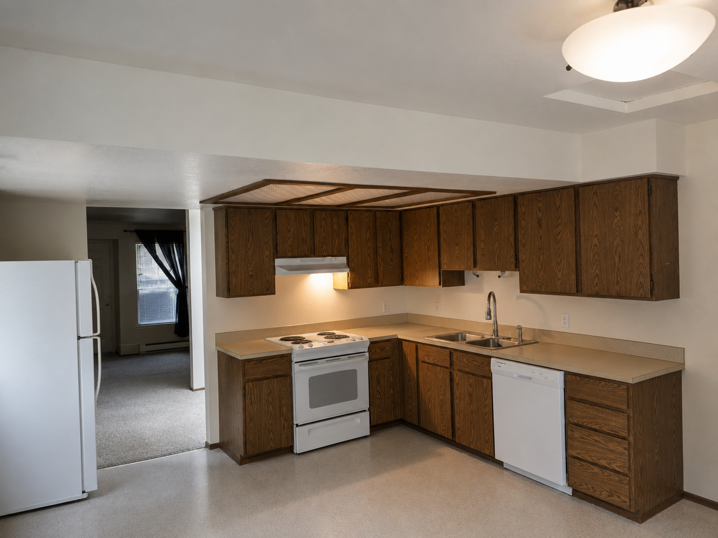 Kitchen before remodel — original oak cabinets and laminate flooring