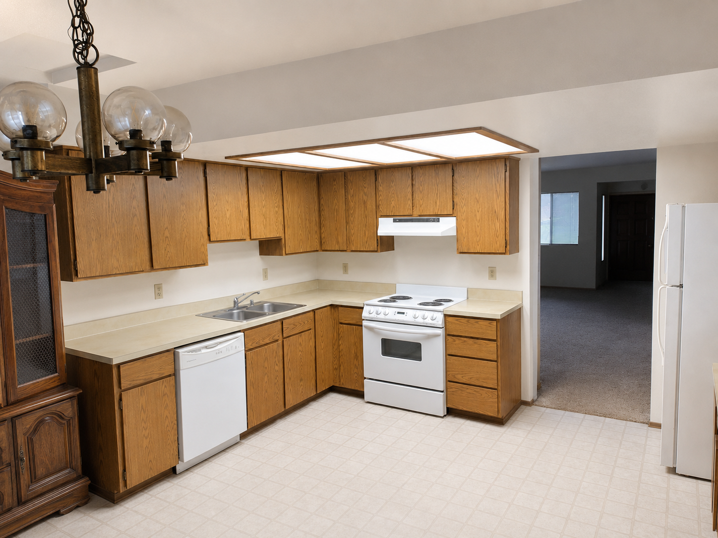 Kitchen before remodel — original oak cabinets and laminate flooring